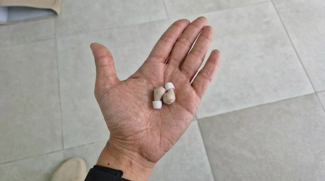 Hände halten Auris Komfort Hörgeräte